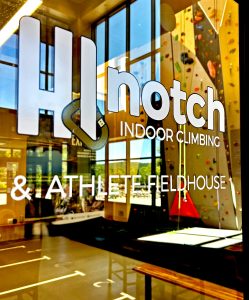 The Hi Notch Indoor Climbing logo on the glass door leading into the facility.