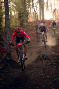 Image of 3 male mountain bike racers racing down a hill at the 2025 UCI MTB World Series at Mt Van Hoevenberg.