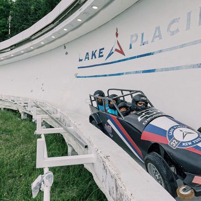 A family goes down the bobsled track during the summer.