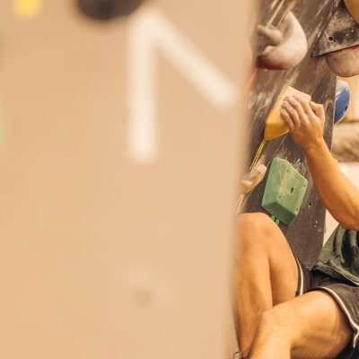 A rock climbing up on a bouldering wall during a competition.