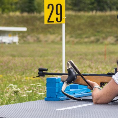 An instructor gives a shooting lesson in the biathlon range on a summer day during our discover biathlon experience.