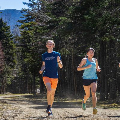 Runners on trails at Mt Van Hoevenberg, Lake Placid NY with Mt Marcy in the background.